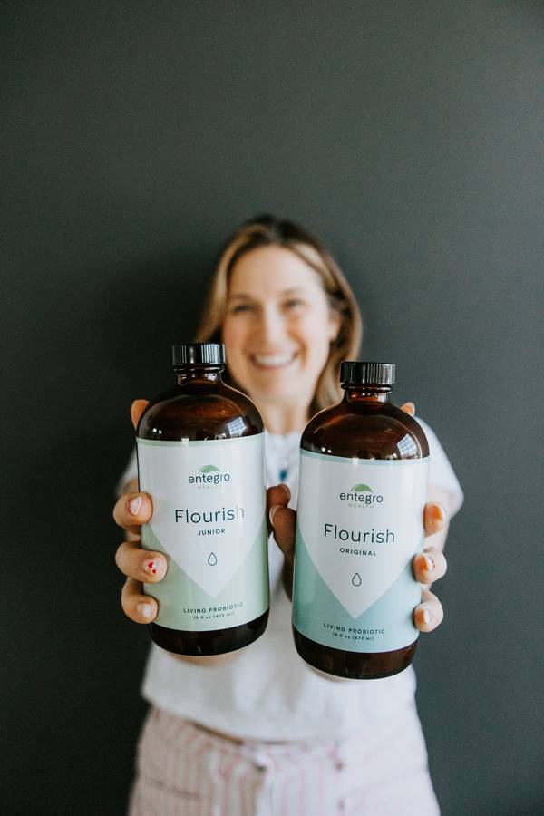 Woman holding Flourish Original and Junior probiotics